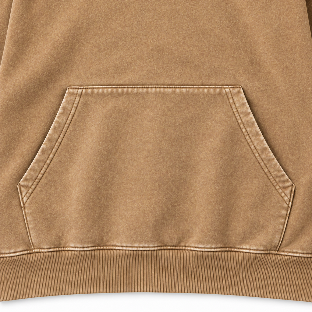 Close-up of the tan hoodie kangaroo pocket, stitching and ribbed hem.