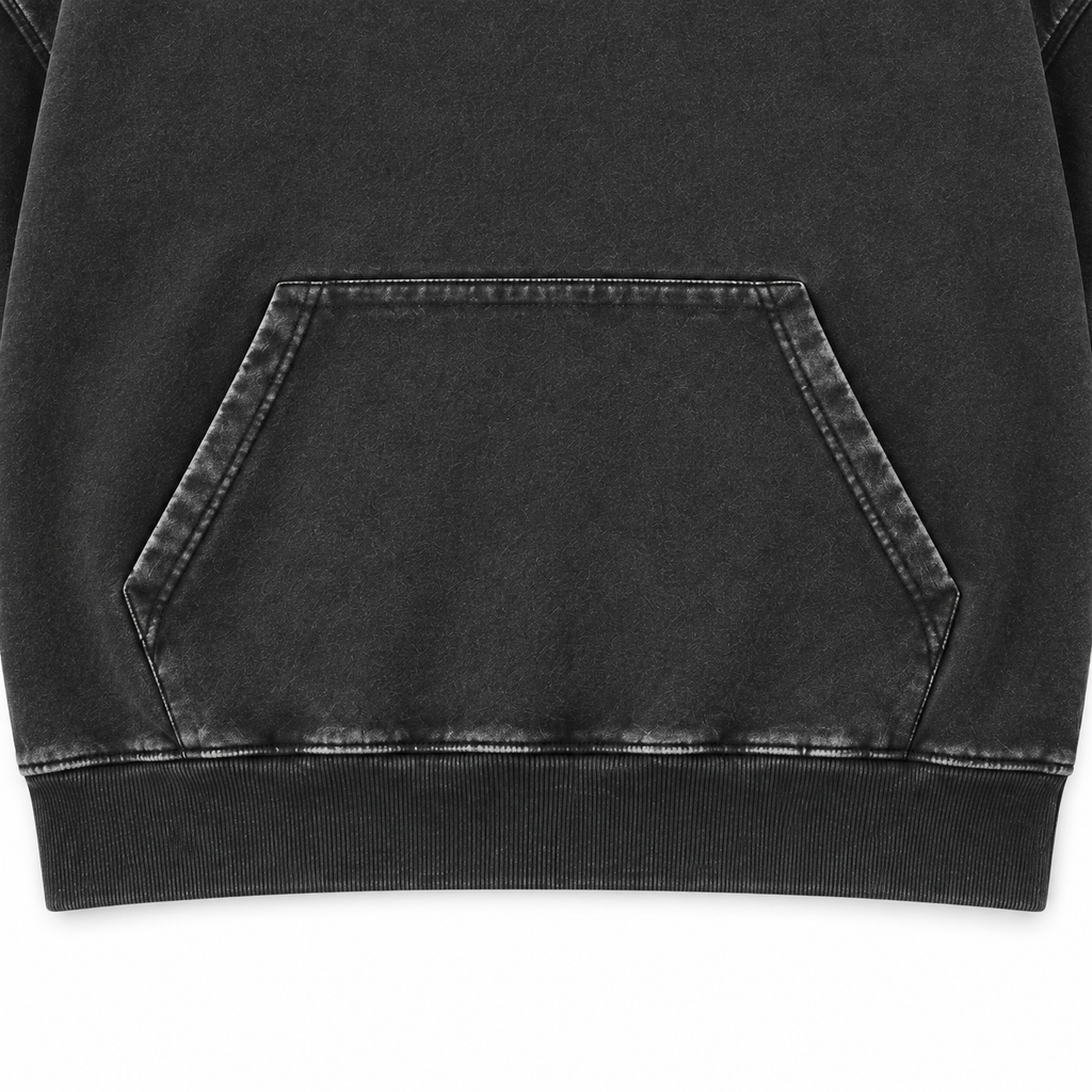 Close-up of the washed black hoodie kangaroo pocket, stitching and ribbed hem.